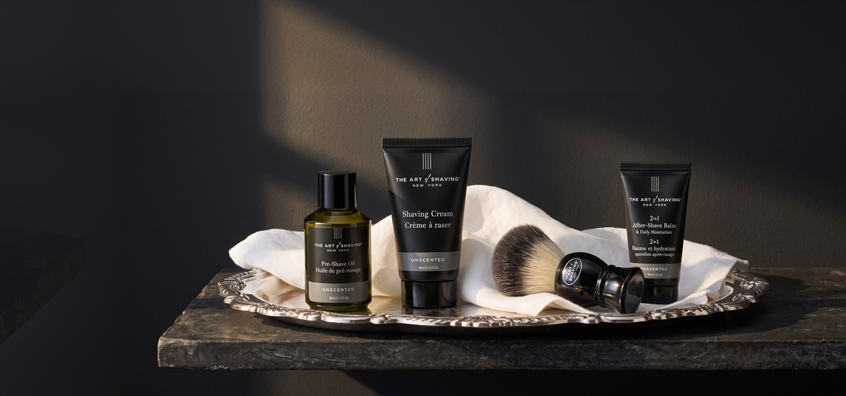 The Art of Shaving pre-shave oil, shaving cream, brush and after-shave balm on a silver tray